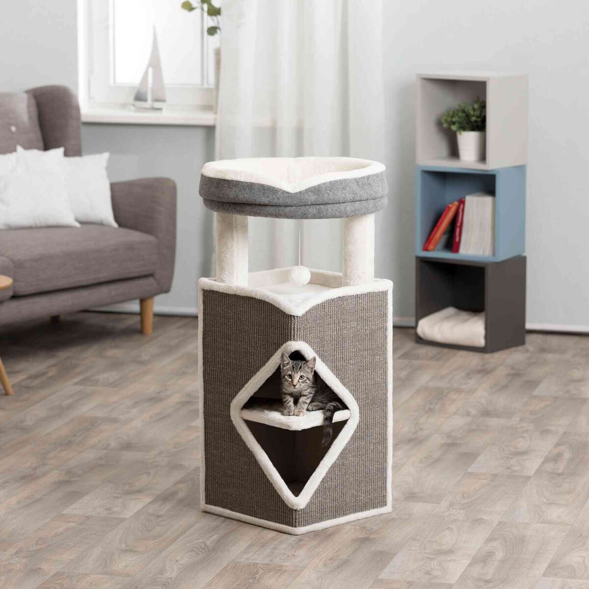Katzenkratzbaum mit grau-weißem Plüschbezug, rautenförmiger Höhle und schlafender Katze, in modernem Wohnzimmer.