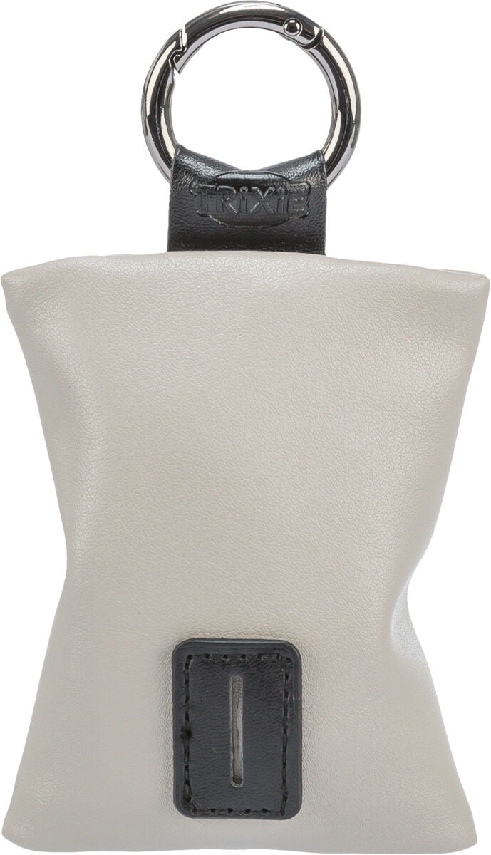 Beigefarbene Tasche mit schwarzem Lederclip und silbernem Ring, Trixie-Logo sichtbar.
