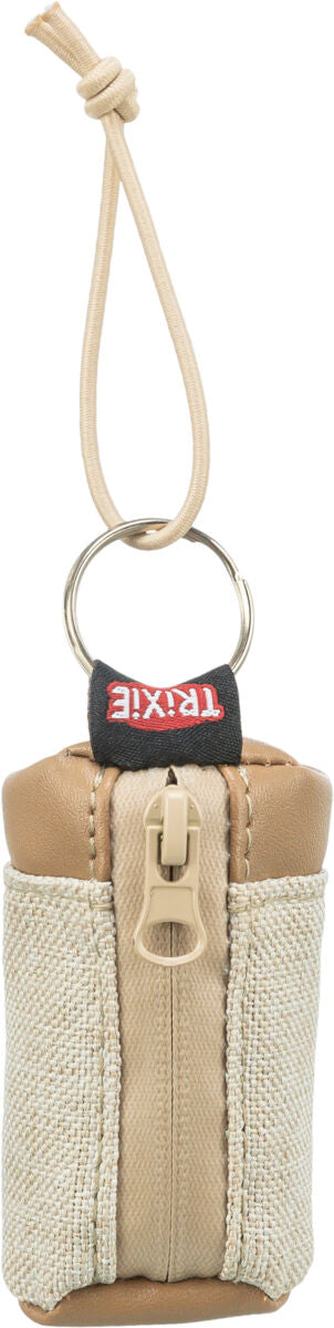 Beigefarbene Tasche mit Reißverschluss und Lederaussehen, an einem Ring mit hellen Schnüren befestigt.