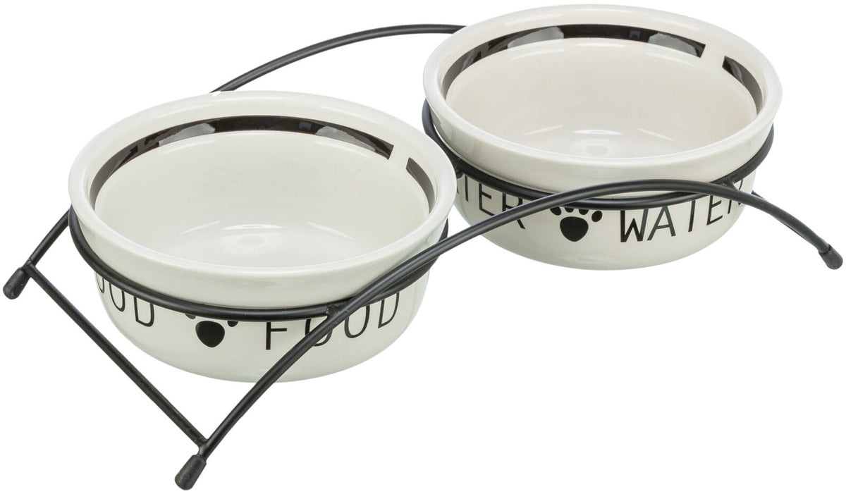 Zwei weiße Futterschalen mit schwarzem Rand in einem schwarzen Metallständer, Text "FOOD" und "WATER" sichtbar.