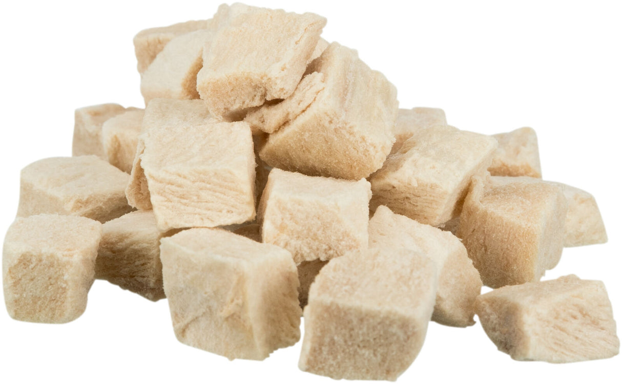 Beige gefriergetrocknete Würfel in einem Stapel auf weißem Hintergrund.