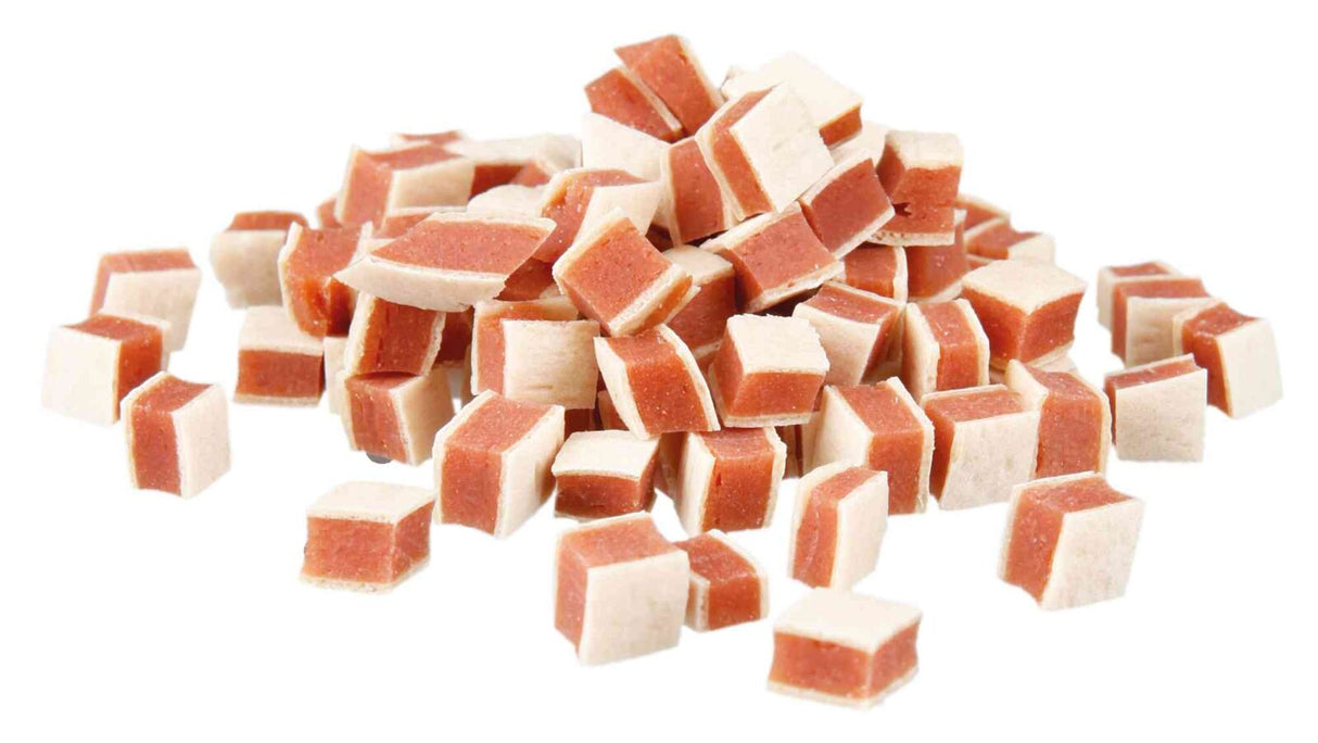 Ein Haufen kleiner, zweifarbiger Würfel in Weiß und Rotbraun, die wie Snacks oder Leckerlis aussehen.