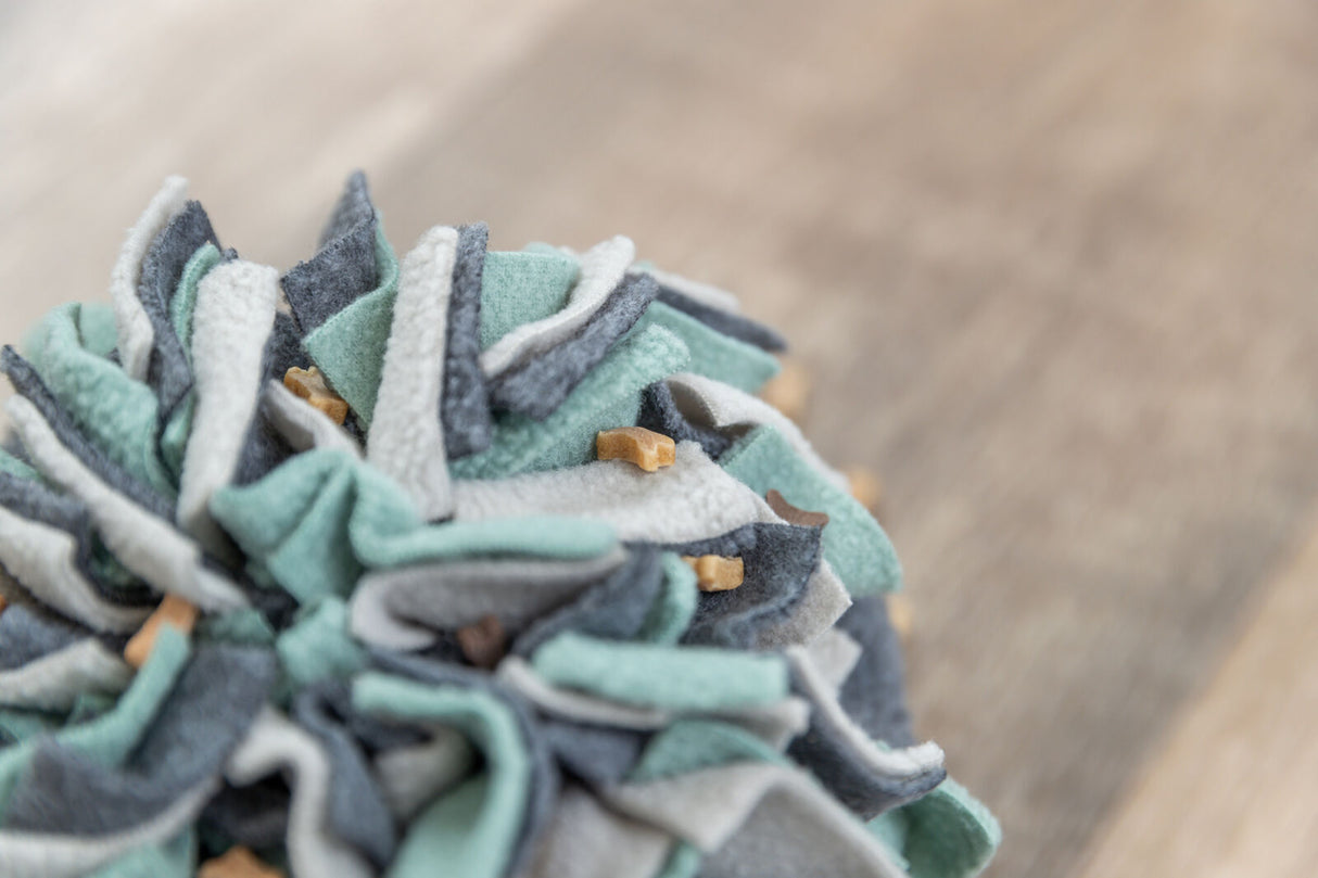 Stoffspielzeug in Blau- und Grautönen mit kleinen Leckerlis dazwischen.