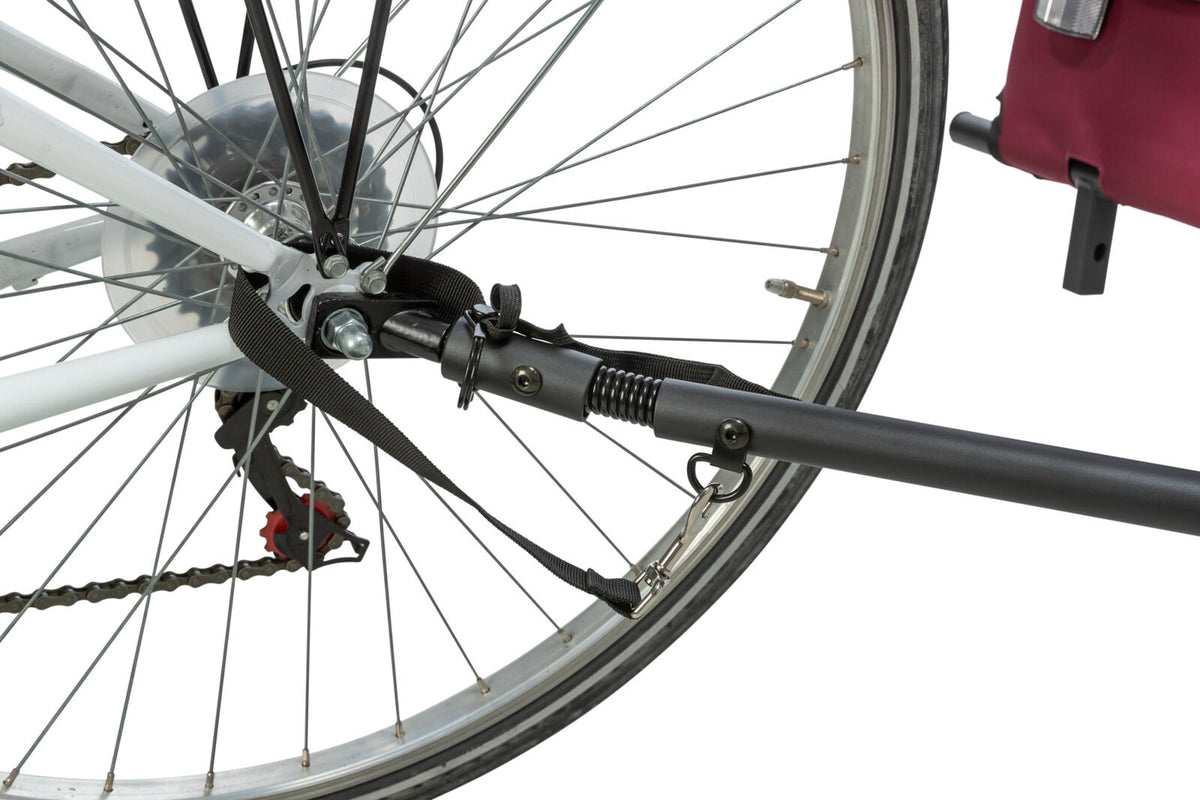 Nahaufnahme eines Fahrradhinterrads mit einer Kupplung für einen Anhänger, befestigt an der Achse.