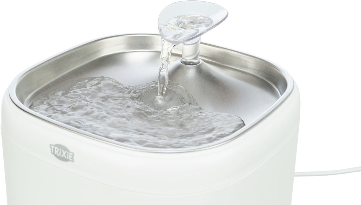 Automatischer Wasserspender mit transparenter Auslaufkappe und Edelstahlwanne, Wasser fließt in die Schale.