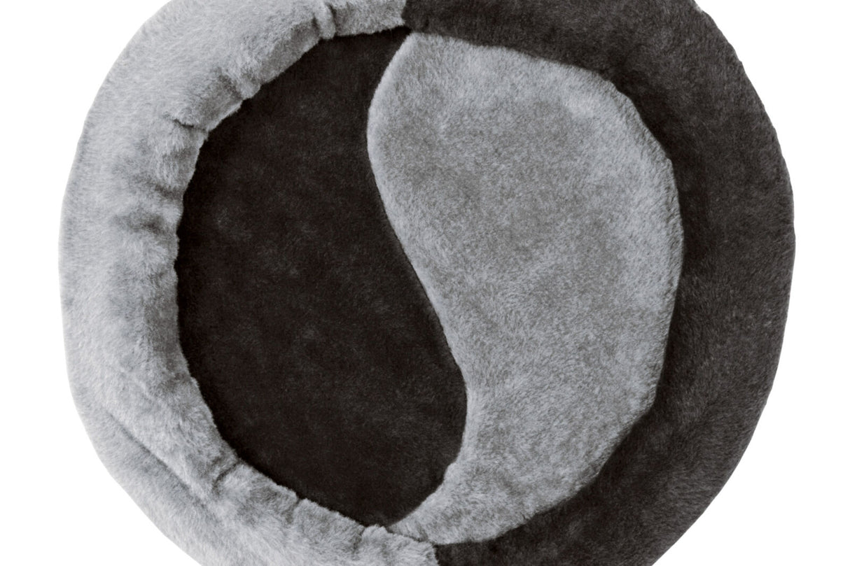Rundes Bett mit Yin-Yang-Muster in Grau- und Schwarztönen aus flauschigem Material.