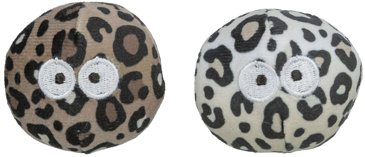 Zwei runde, plüschartige Spielzeuge mit Leopardenmuster und aufgestickten weißen Augen, links beige, rechts weiß.