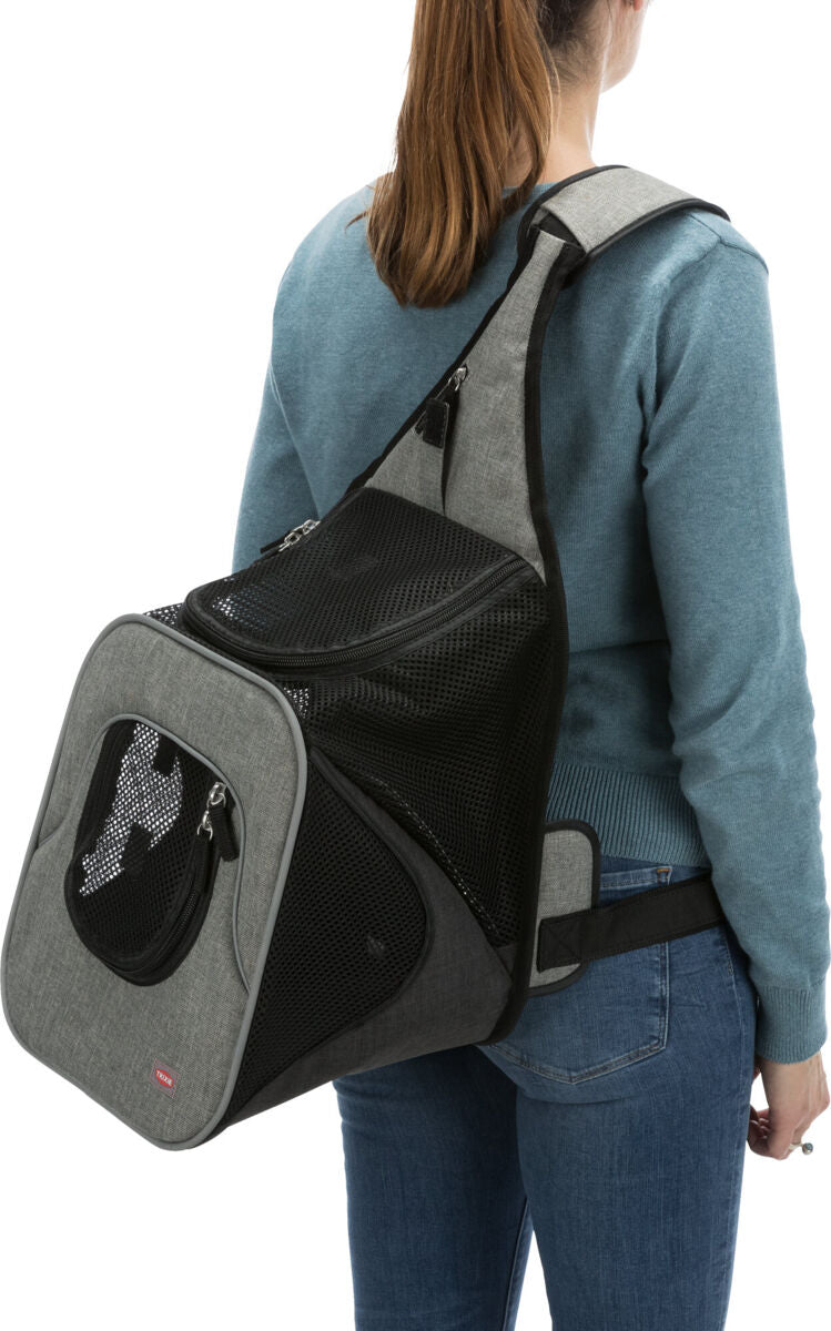 Person trägt einen grauen Tragerucksack mit schwarzem Netz auf dem Rücken, blauer Pullover, blaue Jeans.