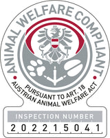 Rundes Emblem mit Adler, Pfotenabdruck und Text: "Animal Welfare Compliant" und "Pursuant to Art. 18 Austrian Animal Welfare Act".