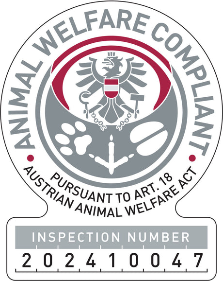 Rundes Emblem mit Adler, Tatzenabdruck, Hufeisen und Text "ANIMAL WELFARE COMPLIANT" in Grau und Rot, Inspektionsnummer 202410047.