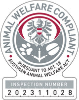 Plakette mit Adler, Tierspuren, Text „Animal Welfare Compliant, Inspection Number 202311028“ in Grau und Rot.