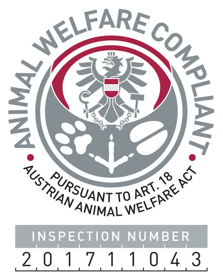 Tierwohl-Siegel in Grau und Rot mit Adler und Tierpfoten, Text "ANIMAL WELFARE COMPLIANT" und Inspektionsnummer "201711043".