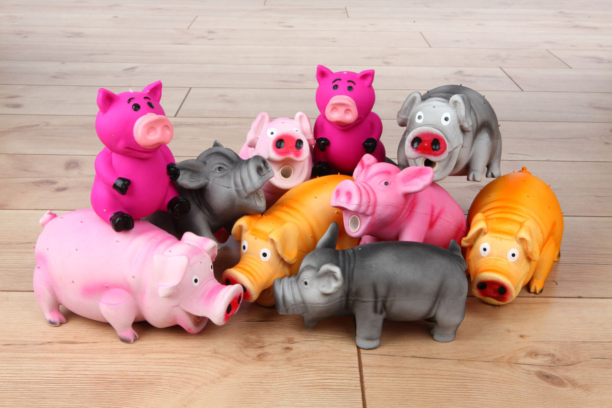 Mehrfarbige Spielzeugschweine stehen auf einem Holzboden in einer Gruppe zusammen.