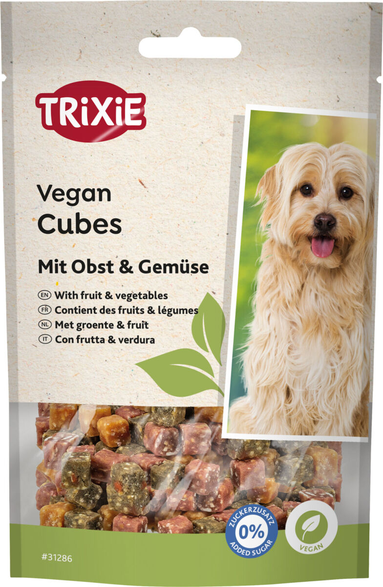 Verpackung von TRIXIE Vegan Cubes mit Obst und Gemüse abgebildet, daneben ist ein Hund zu sehen.