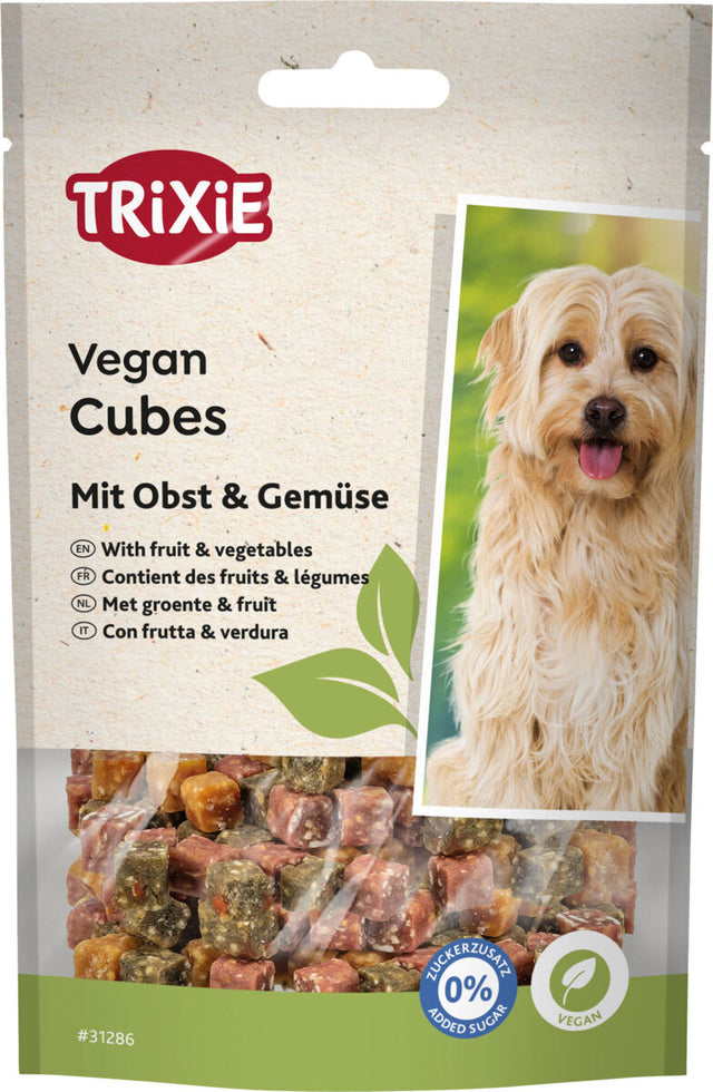 Verpackung von TRIXIE Vegan Cubes mit Obst und Gemüse abgebildet, daneben ist ein Hund zu sehen.