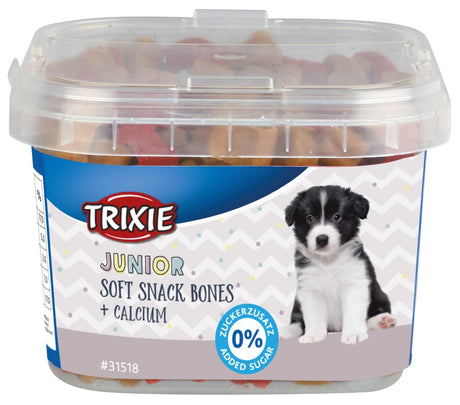 Ein Plastikbehälter mit durchsichtiger Abdeckung, gefüllt mit Hundesnacks, abgebildet ein Welpe, Text "Junior Soft Snack Bones + Calcium".