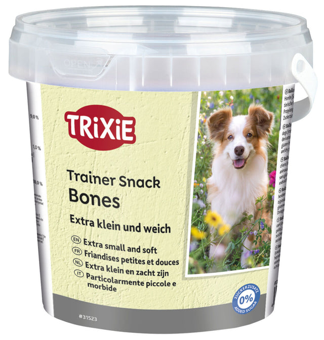 Durchsichtiger Eimer mit Hundesnacks, gelbes Etikett mit "Trixie Trainer Snack Bones", Bild eines Hundes, 0% Zuckerzusatz.