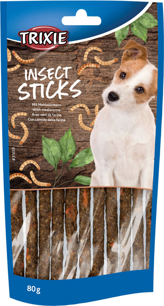 Verpackung von Hundefutter mit der Aufschrift "Insect Sticks", einem Hundebild und Mehlwürmern auf holzartigem Hintergrund.