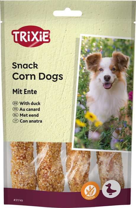 Verpackung mit dem Text "TRIXIE Snack Corn Dogs Mit Ente" und einem Bild von einem Hund vor einer blühenden Wiese.