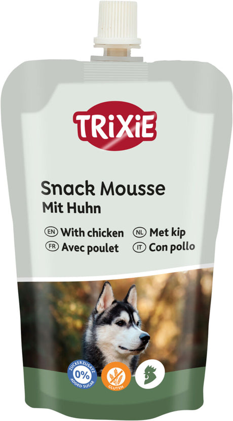 Trixie Snack Mousse für Hunde mit Huhn in einer Quetschpackung, abgebildet mit einem Foto eines Hundes.
