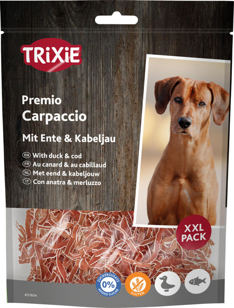 Eine Tüte Hundefutter von Trixie mit der Aufschrift "Premio Carpaccio mit Ente &amp; Kabeljau", daneben Bild eines Hundes.