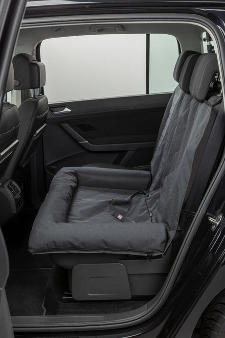 Schwarzer Autositzbezug mit gepolstertem Hundeplatz in der Rückbank eines Autos.