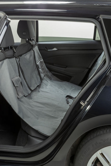 Graue Autoschondecke ist auf der Rückbank eines Autos ausgebreitet.