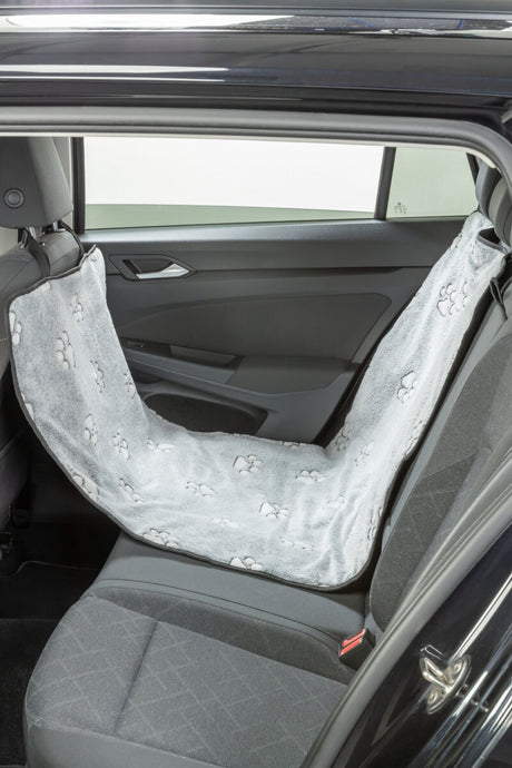 Graue Autoschondecke mit Pfotenmuster hängt auf dem Rücksitz eines Autos.