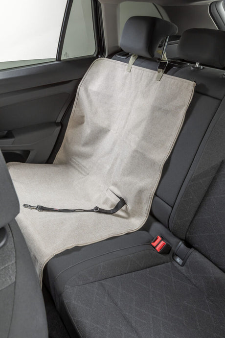 Beige Schutzdecke für Rücksitzbank im Auto mit Befestigung und Gurtclip.