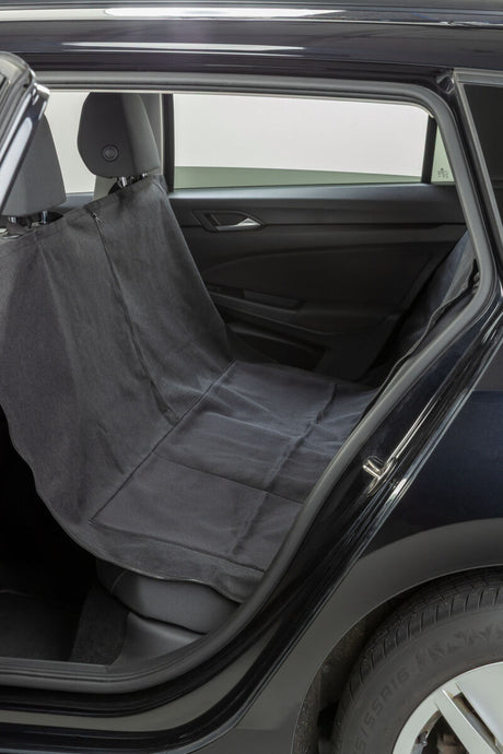 Schwarze Autoschondecke auf Rücksitz eines Autos, sichtbar durch geöffnete Autotür.