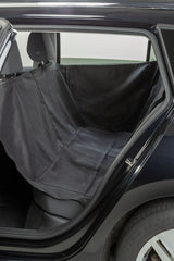 Schwarze Autoschondecke auf Rücksitz eines Fahrzeugs ausgebreitet.