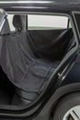 Schwarze Autoschondecke auf Rücksitz eines Fahrzeugs ausgebreitet.