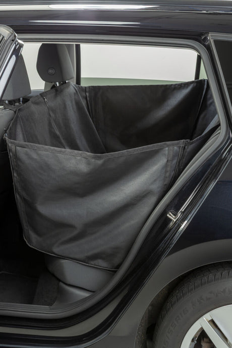 Schwarze Autoschondecke ist auf der Rückbank eines geöffneten Autotürs sichtbar.