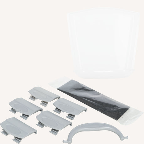 Graue und transparente Plastikteile mit einer schwarzen rechteckigen Verpackung auf hellem Hintergrund.