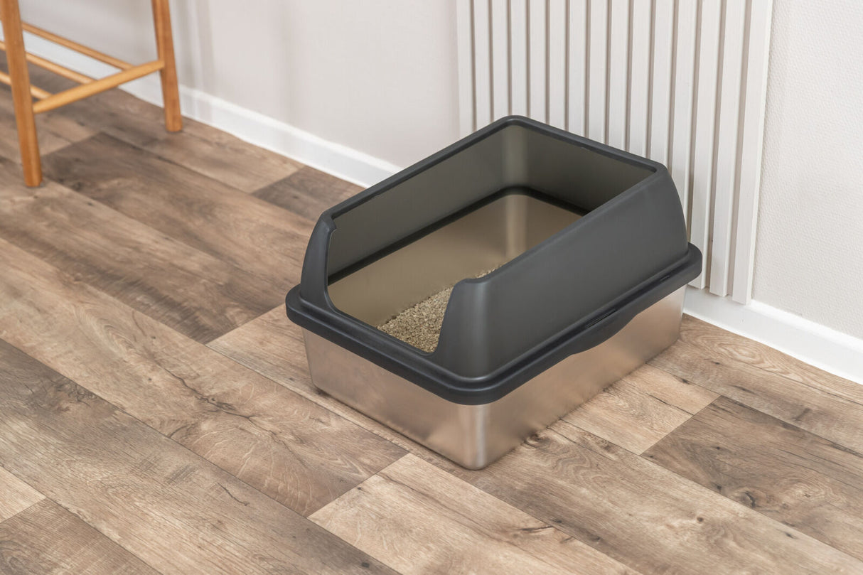 Offene Katzentoilette mit schwarzem Rand steht auf einem Holzfußboden.