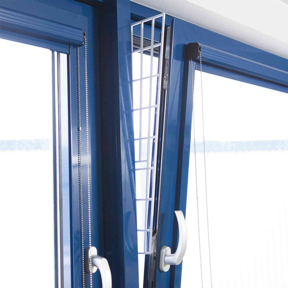 Ein gekipptes blaues Fenster mit einem weißen Gitter, das in den Spalt eingesetzt ist.