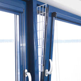 Ein gekipptes blaues Fenster mit einem weißen Gitter, das in den Spalt eingesetzt ist.