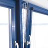 Ein gekipptes blaues Fenster mit einem weißen Gitter, das in den Spalt eingesetzt ist.