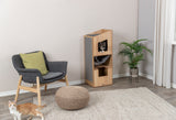Wohnzimmer mit einem grauen Sessel, einem Holzturm mit Katze, einem runden Hocker und einer Pflanze.