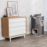Holzkommode mit weißen Schubladen, darauf Bilderrahmen und eine Kamera, daneben Kratztonne mit Katze, Text "home sweet home".