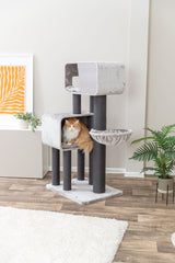 Orange-weiße Katze liegt in grauem Katzenkratzbaum mit mehreren Ebenen und Höhlen.