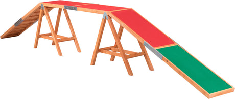 Holzkonstruktion mit roter und grüner Oberfläche, bestehend aus mehreren geneigten Platten auf Holzgestellen.