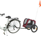 Ein weißes Fahrrad mit einem angehängten, rot-grauen Fahrradanhänger und orangener Fahne.