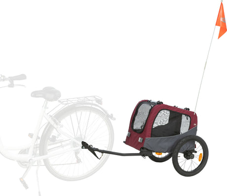 Ein roter Fahrradanhänger mit schwarzen Rädern und Sicherheitsflagge ist an ein weißes Fahrrad angehängt.
