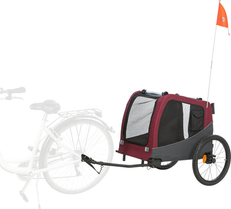 Roter Fahrradanhänger mit zwei Rädern, schwarzem Rahmen und kleinem orangem Wimpel, an Fahrrad angehängt.