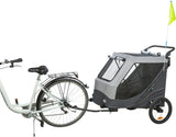 Silbernes Fahrrad mit angeschlossenem grauem Fahrradanhänger, schwarzes Netzfenster, gelbe Sicherheitsfahne.