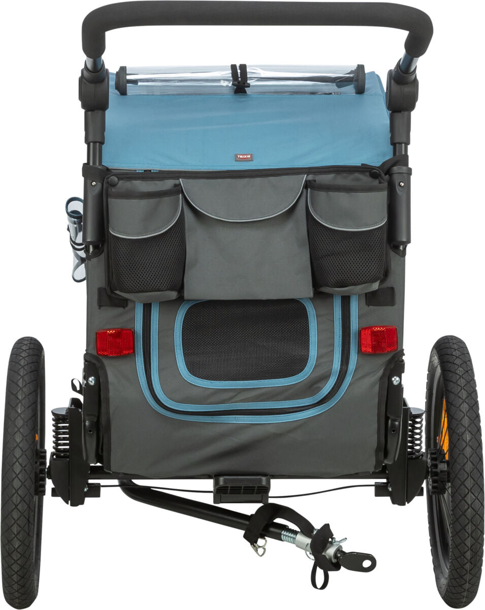 Grauer Fahrradanhänger mit blauen Akzenten, zwei Rädern und Taschen, sowie schwarzem Griff oben und Reflektoren hinten.