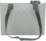 Graue, gesteppte Tasche mit zwei langen, schwarzen Trägern und Schnallen, rechteckige Form.