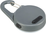 Grauer runder Anhänger mit USB-Anschluss und Druckknopf, an einem silbernen Karabiner befestigt.