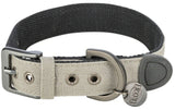 Ein beige-graues Hundehalsband mit Metallschnalle, Ösen, D-Ring und einem Trixie-Logo am Anhänger.